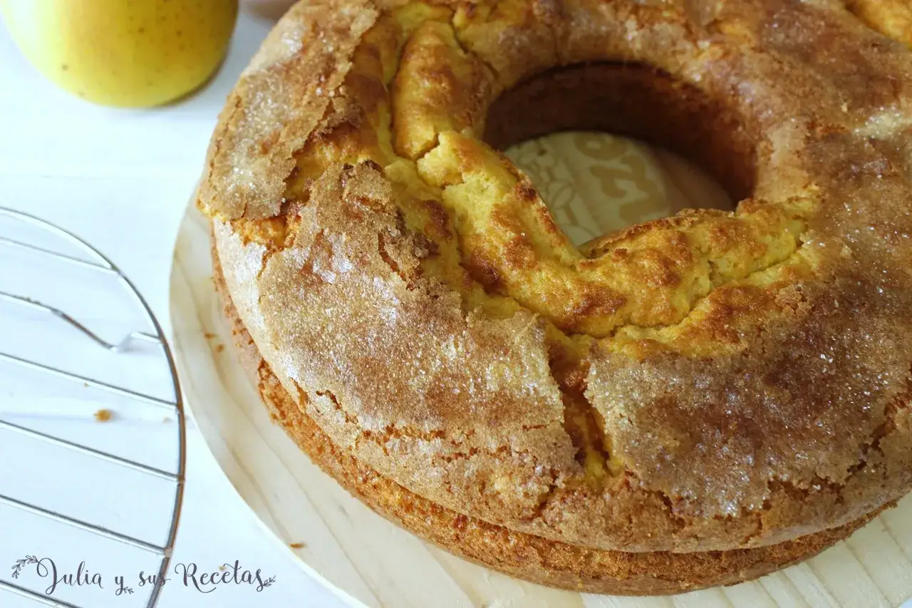 Bizcocho de manzana y naranja con una corteza dorada y azucarada, listo para disfrutar.