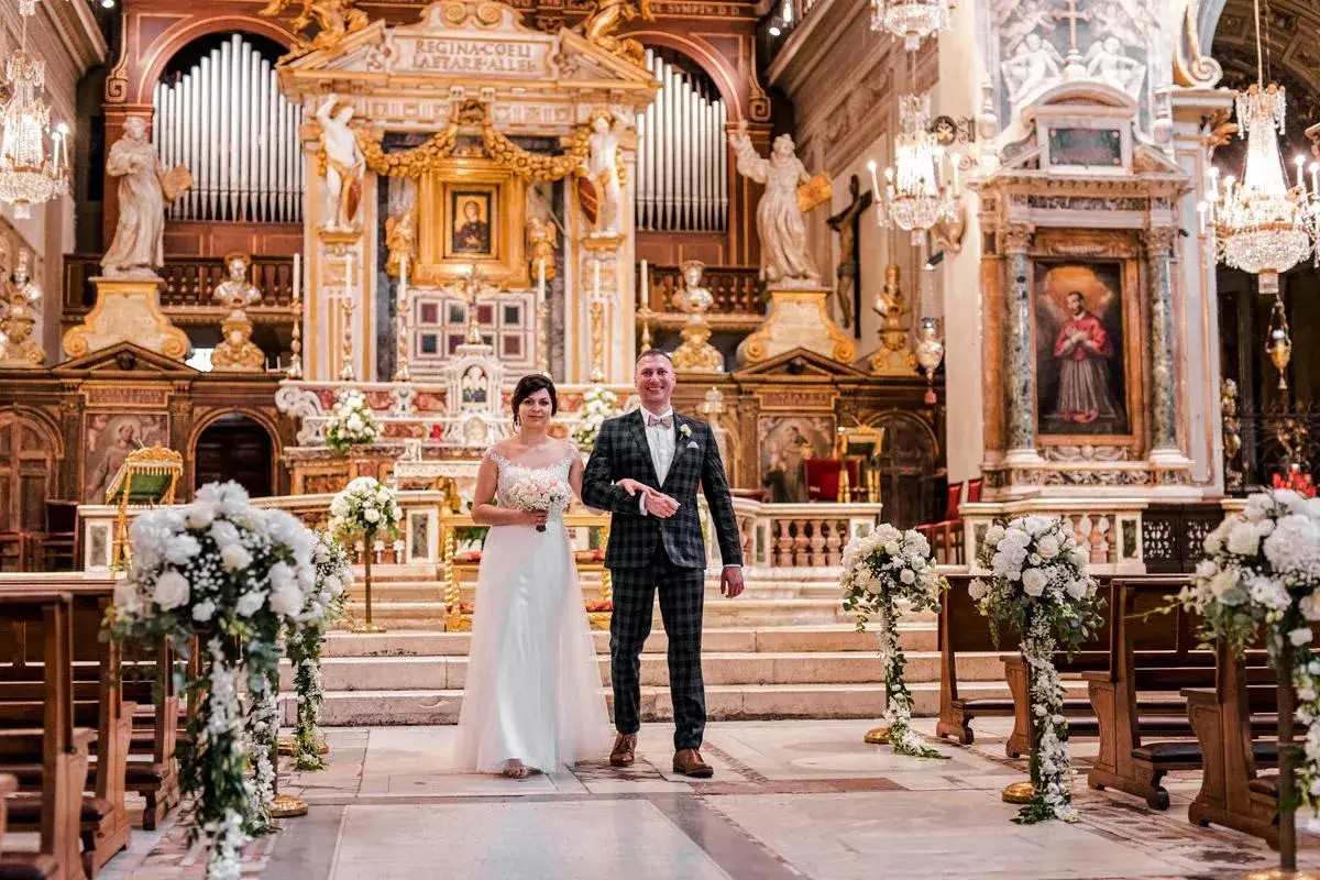 Para młoda idzie do ołtarza w kościele, gdzie odbędzie się ich ślub rzymski.