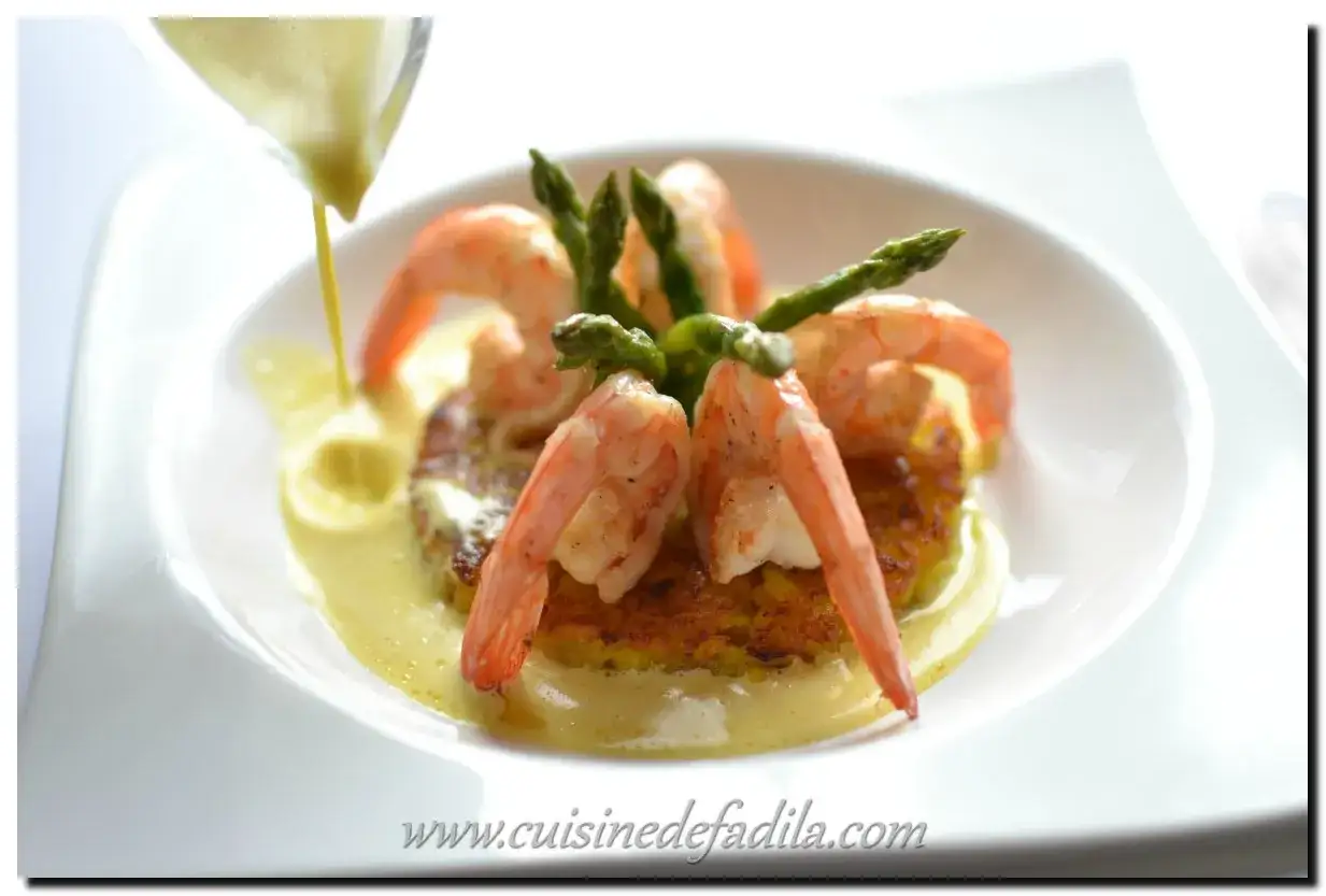 Crevettes et asperges sur un lit de riz al salto, nappés d'une sauce crémeuse.