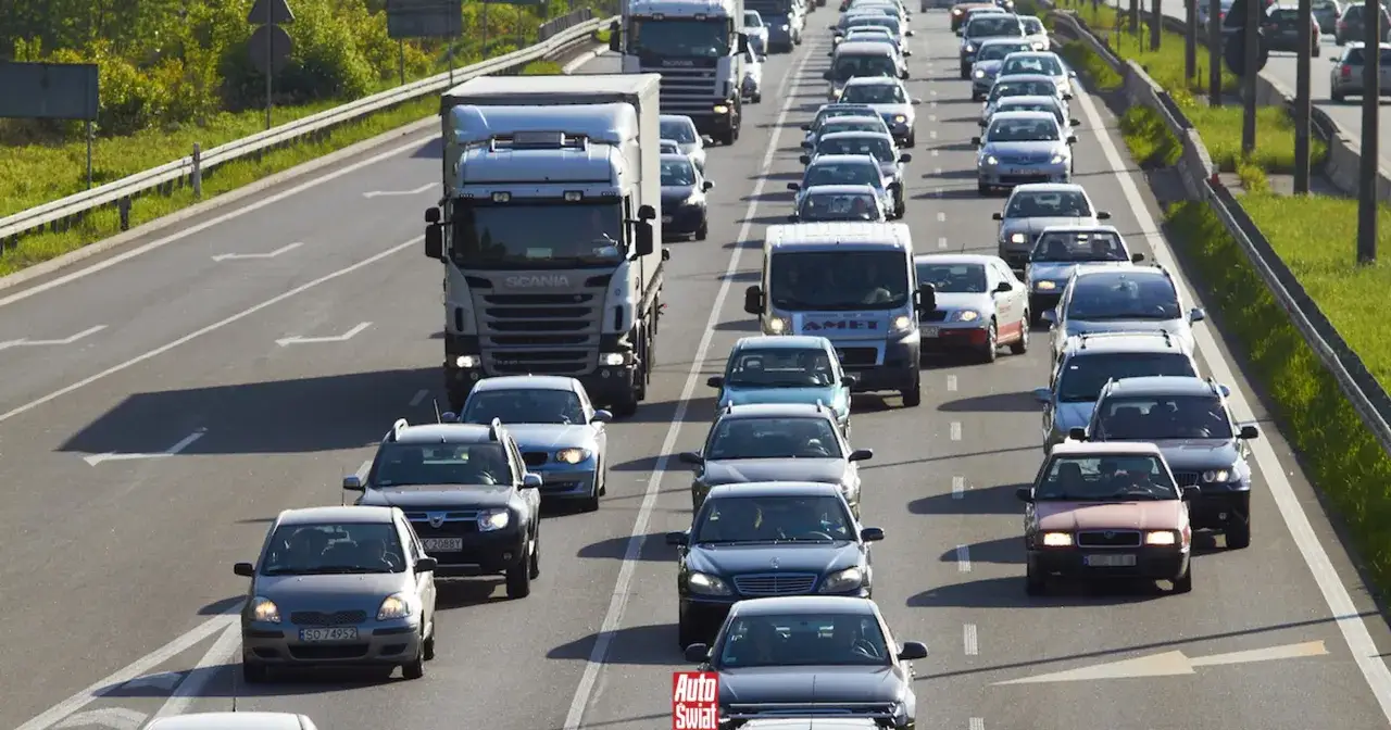 Korki na autostradzie, samochody i ciężarówki stoją w rzędzie. Jazda na suwak nie pomaga, ruch jest powolny.