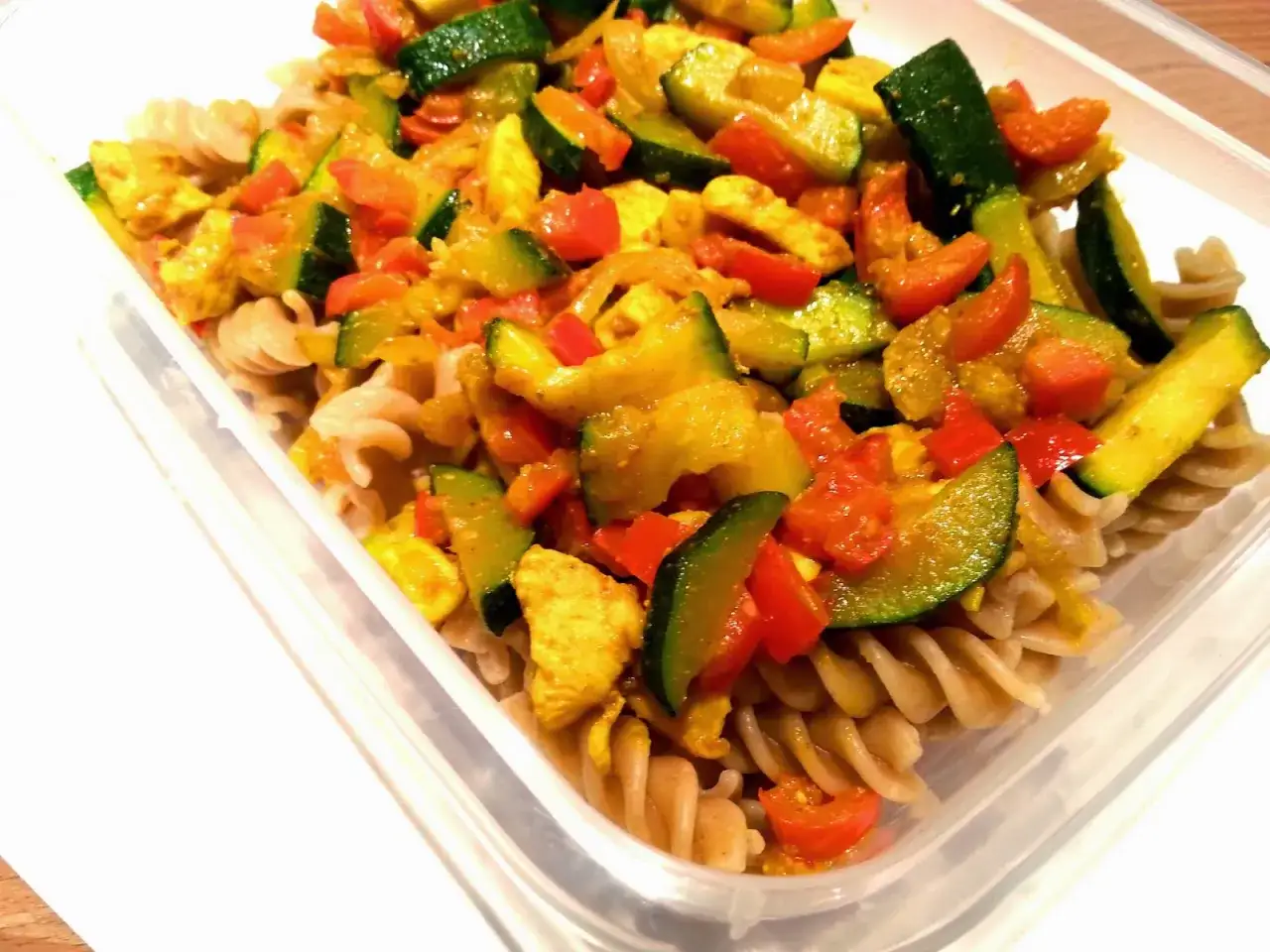 Pyszny makaron pełnoziarnisty z kurczakiem, cukinią i papryką w sosie curry.