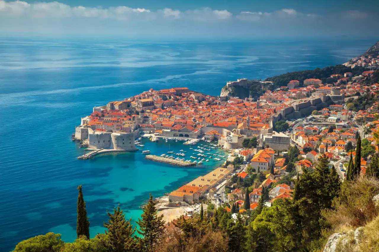 Dubrovniks Altstadt mit roten D&auml;chern und blauer Adria. Das Wetter in Kroatien im Oktober ist oft noch mild und sonnig.