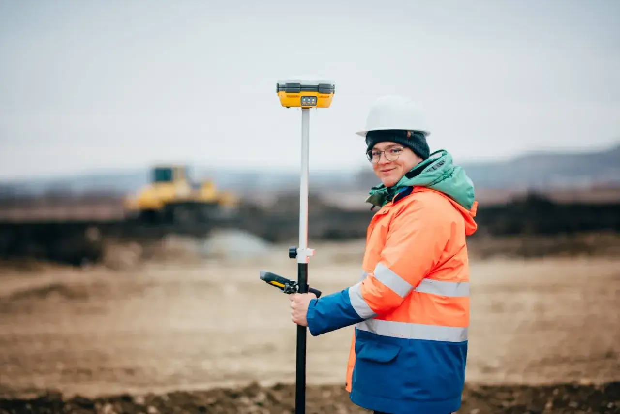 Geodeta w terenie z urządzeniami pomiarowymi