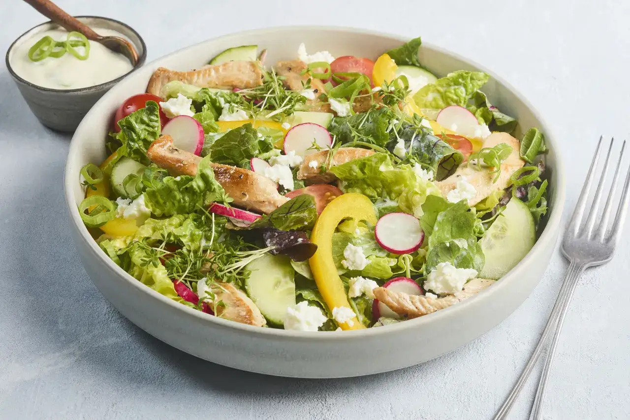Frischer Salat mit Putenstreifen, Gurken, Radieschen, Tomaten, Paprika und Feta. Dazu ein cremiges Dressing.