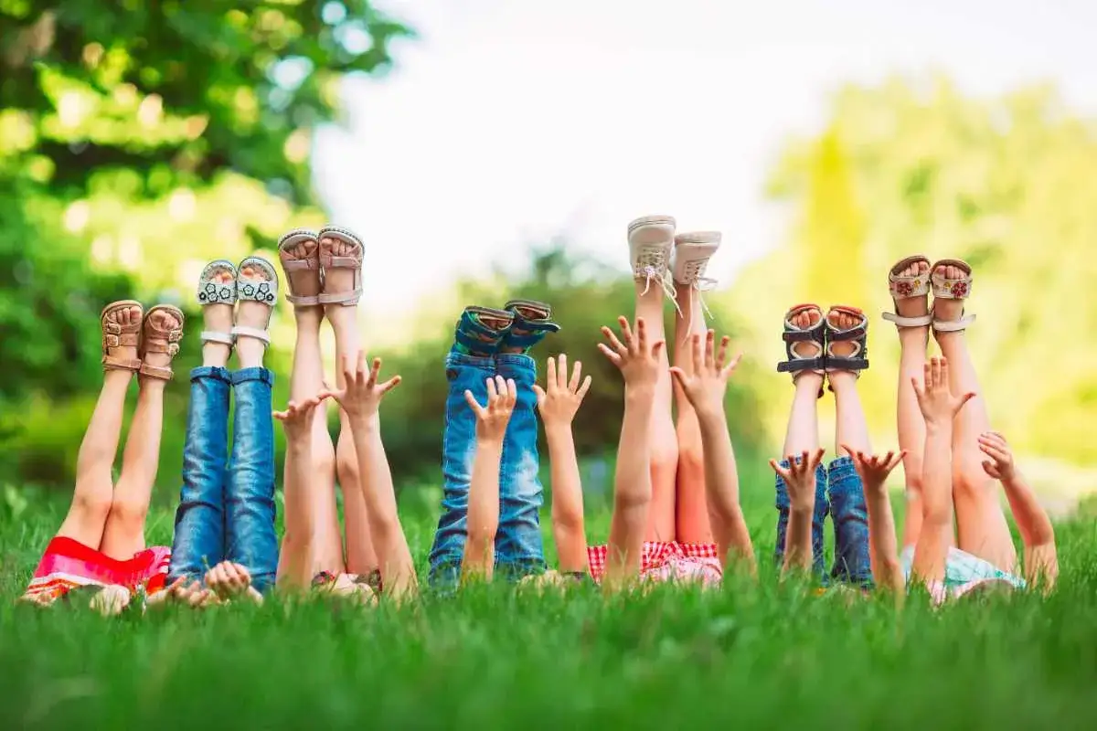 Bambini con le gambe in aria, felici al loro campo estivo.