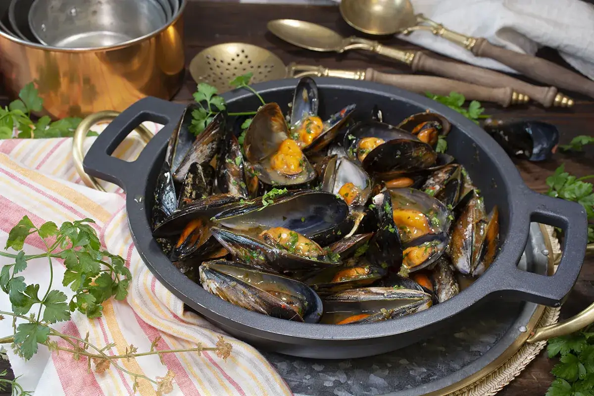 Mejillones en una cazuela, listos para disfrutar de una deliciosa salsa gallega.