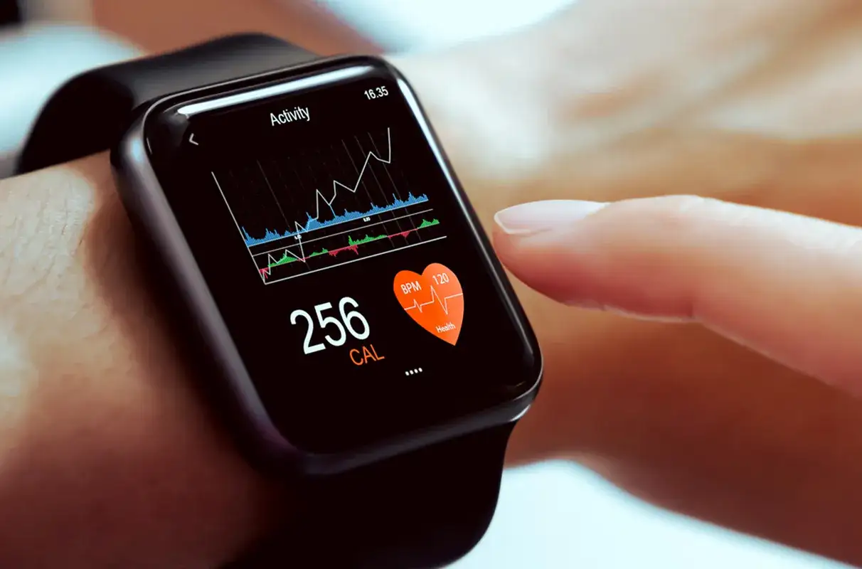 Eine Smartwatch zeigt Kalorienverbrauch (256 CAL) und Herzfrequenz (120 BPM). Sie ist ein modernes Gadget, das Fitnessdaten trackt.