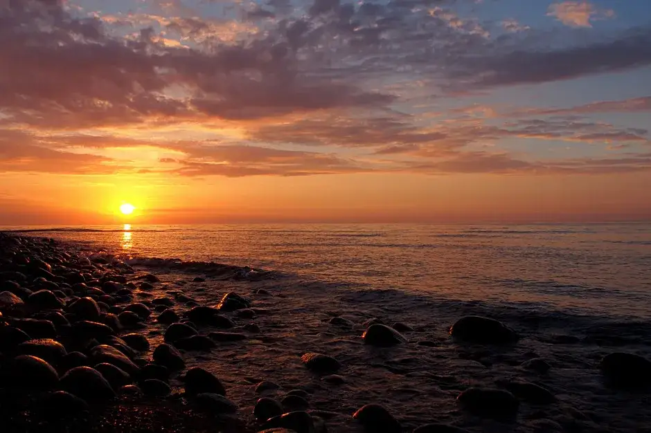 Spokojna plaża nad polskim morzem o zachodzie słońca