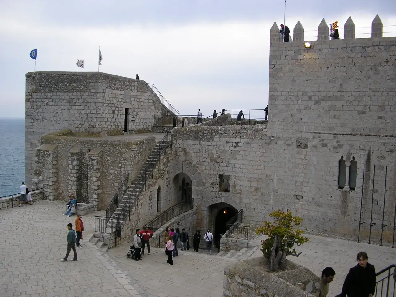 Castillo de Pe&ntilde;&iacute;scola, donde se dice que muri&oacute; el Papa Luna. Gente pasea por sus murallas de piedra y escalinatas.