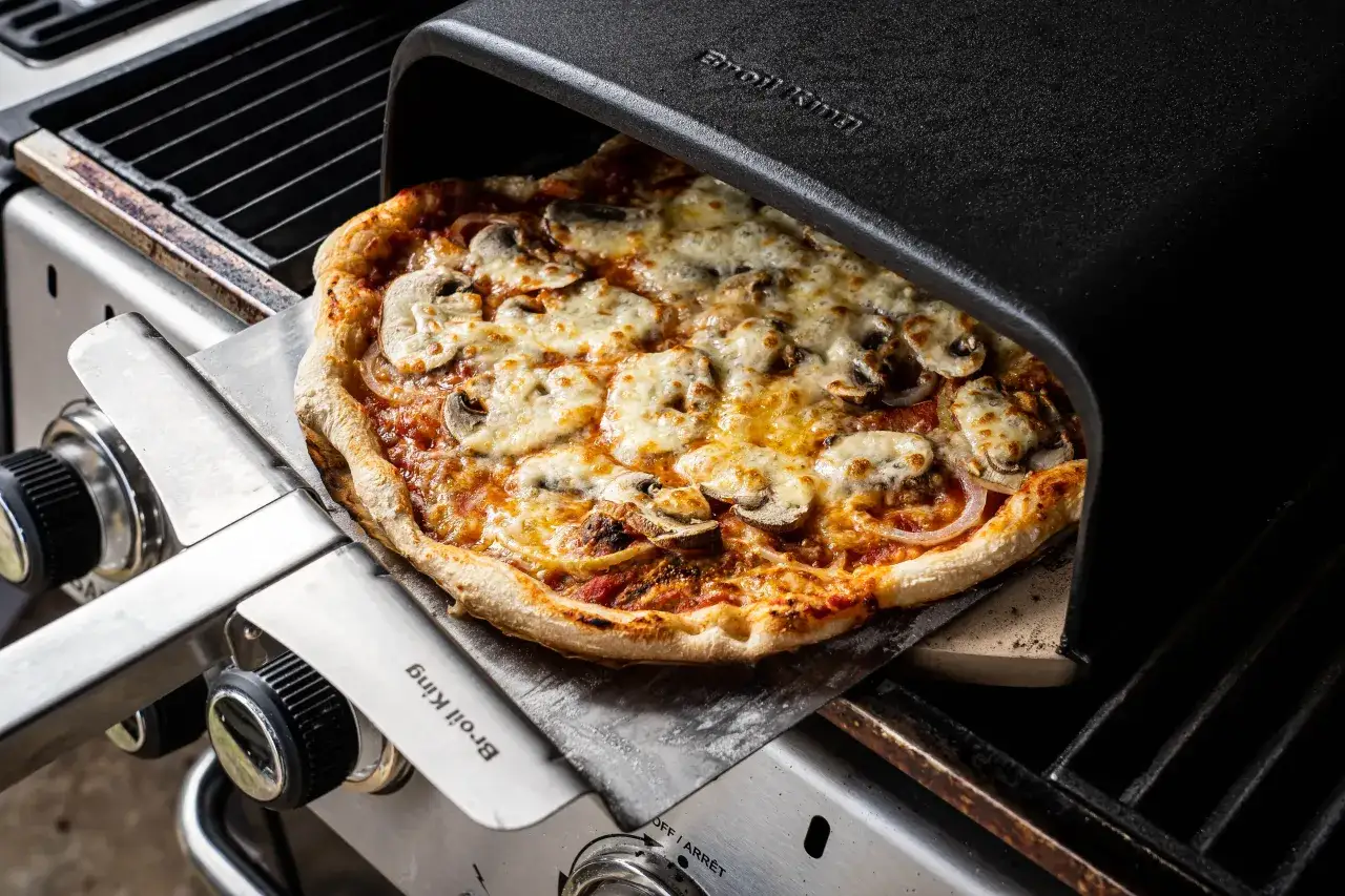 Idealna pizza z grilla, dzięki specjalnej nakładce. Dowiedz się, jak ustawić piekarnik na pizzę, by uzyskać chrupiący spód i idealnie roztopiony ser.