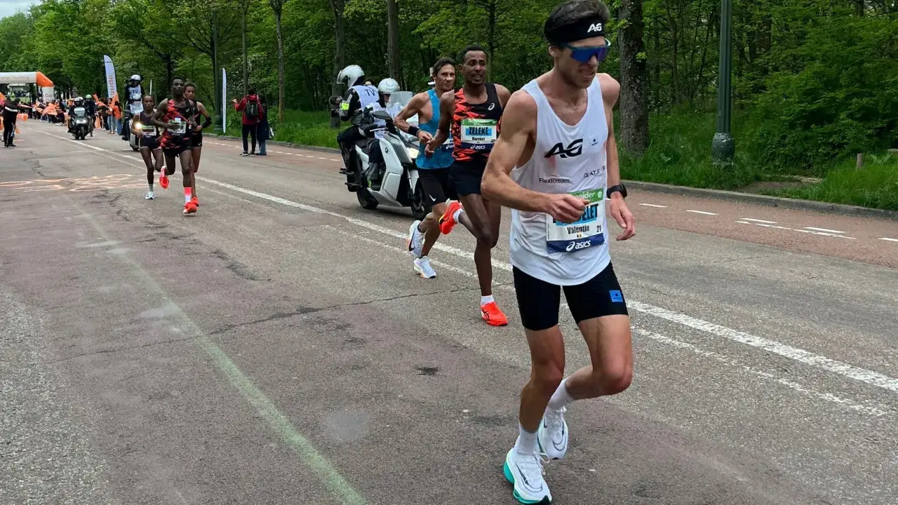 Biegacze w maratonie, zastanawiają się, ile się biegnie 10 km. Jeden z nich, Valentin, ma numer 21.