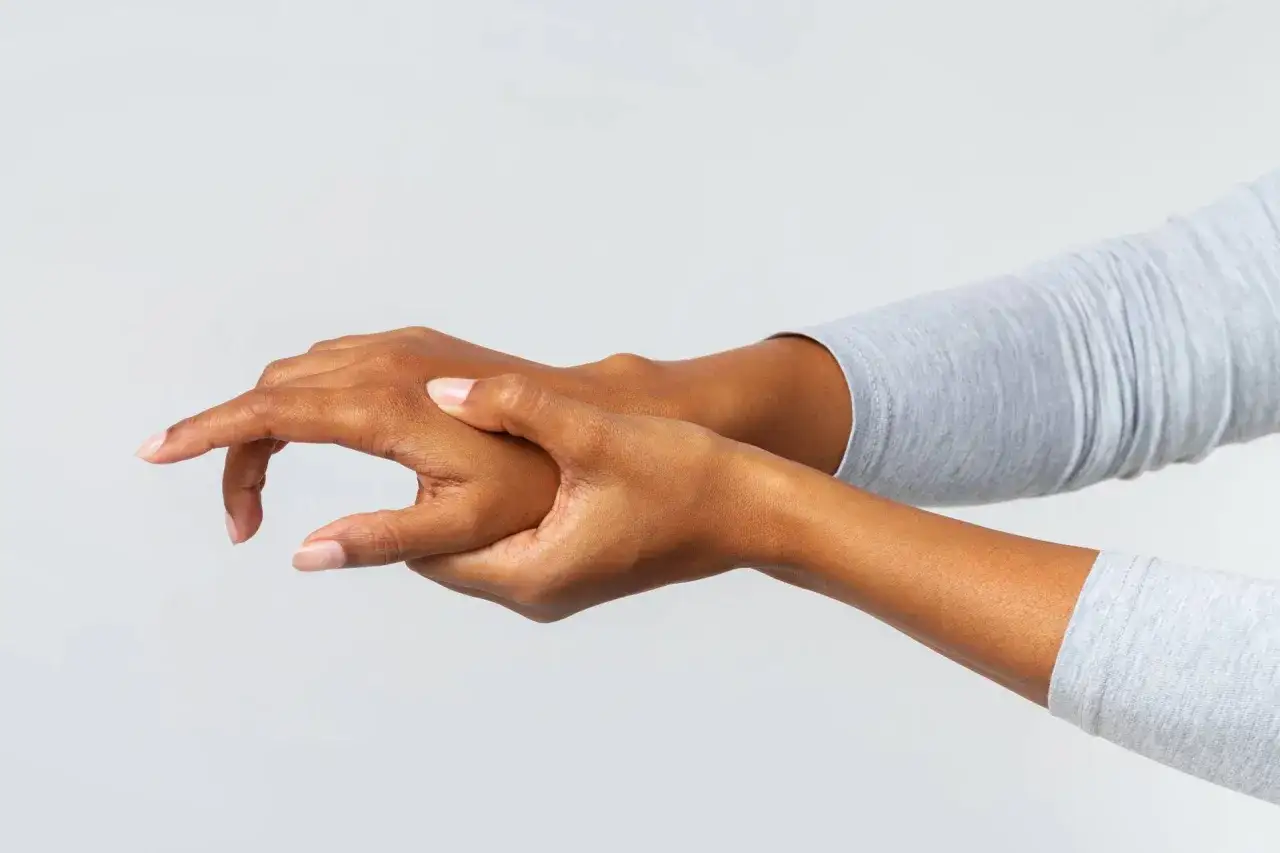 Mano che si massaggia il dorso, alleviando un fastidioso dolore.