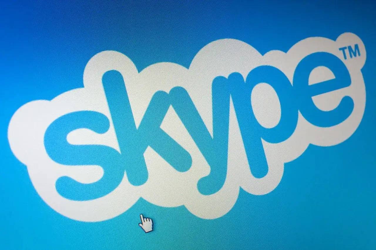 Logo Skype na niebieskim tle. Kursor myszy wskazuje na napis, sugerując, jak usunąć konto Skype.