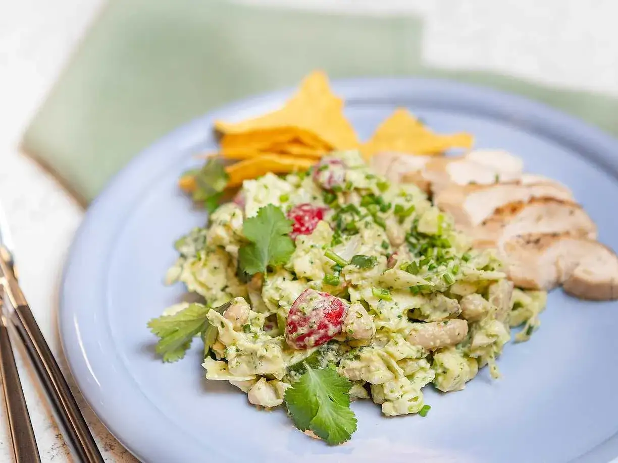En krämig kycklingsallad med avokado och körsbärstomater, serverad med tortillachips och grillad kyckling. Ett perfekt kycklingsallad recept för en lätt lunch.