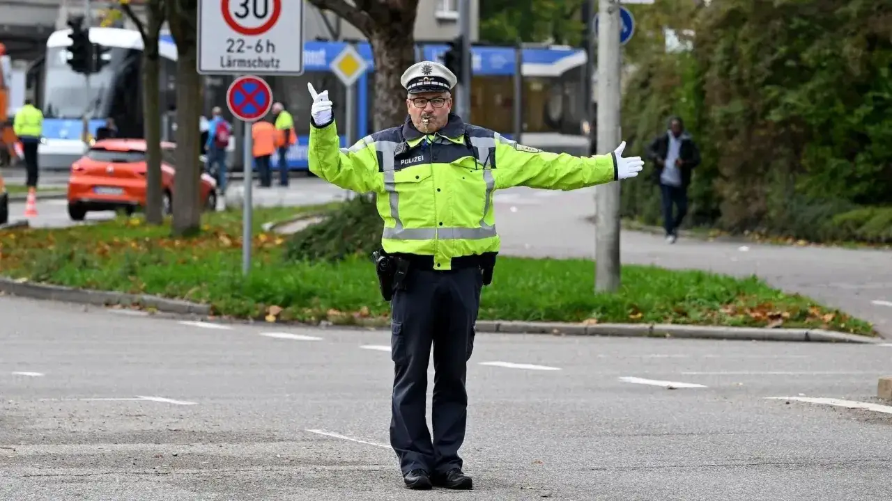 Polizist regelt den Verkehr. Ein polizei verkehrszeichen ist im Hintergrund zu sehen.