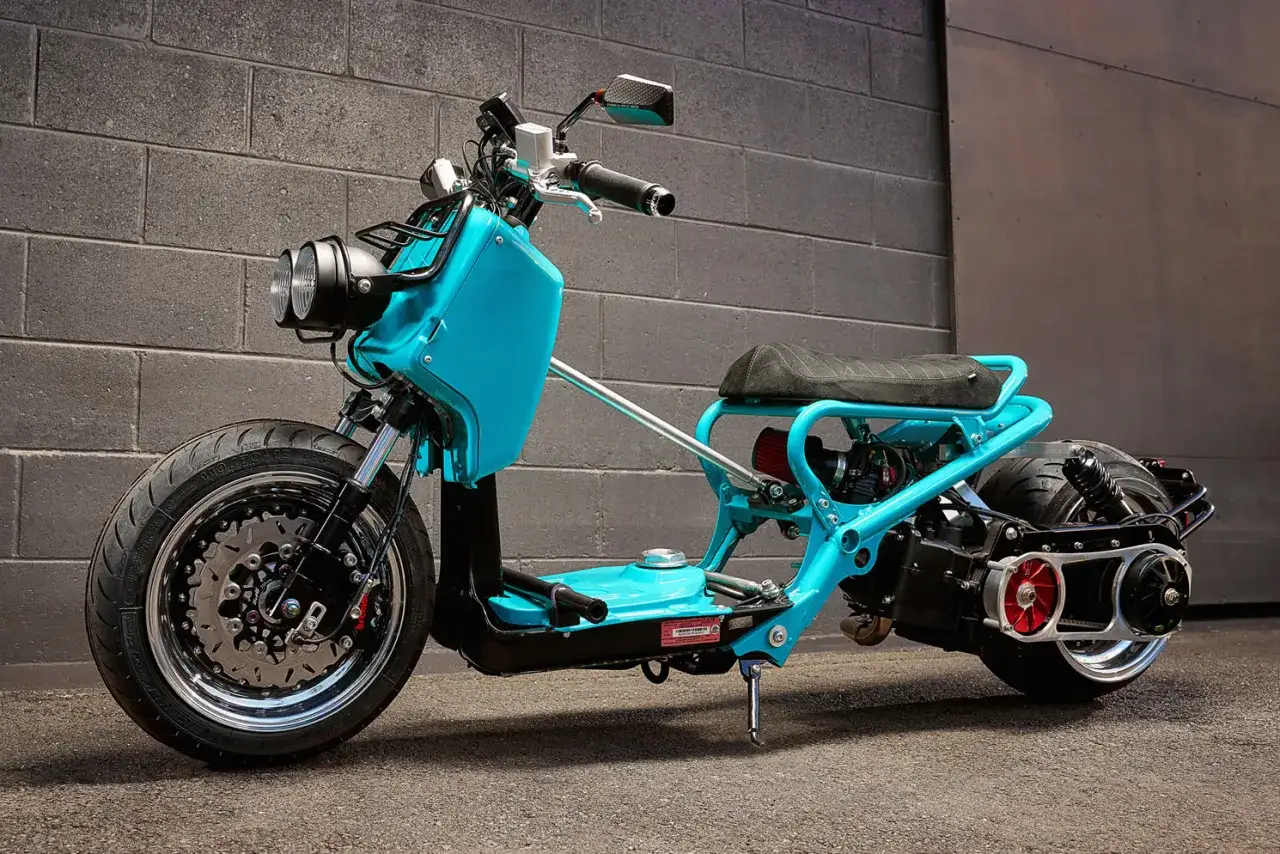 Niebieski Honda Zoomer z customowym stelażem i sportowym filtrem powietrza, gotowy na miejskie przygody.