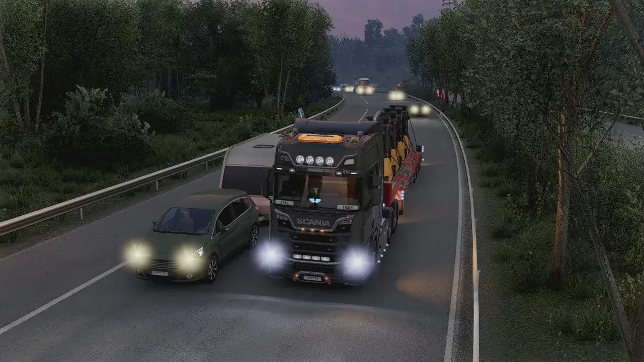 Ciężar&oacute;wka Scania z naczepą przewozi ładunek, a obok niej jedzie samoch&oacute;d osobowy. W tle widać inne pojazdy i las. To świetne mody do ets2!