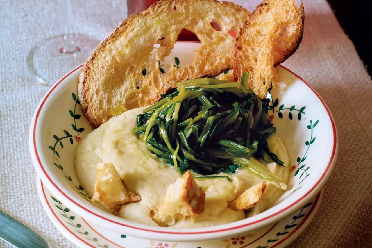 Piatto di fave e cicoria con crostini di pane abbrustolito, un classico della cucina italiana.