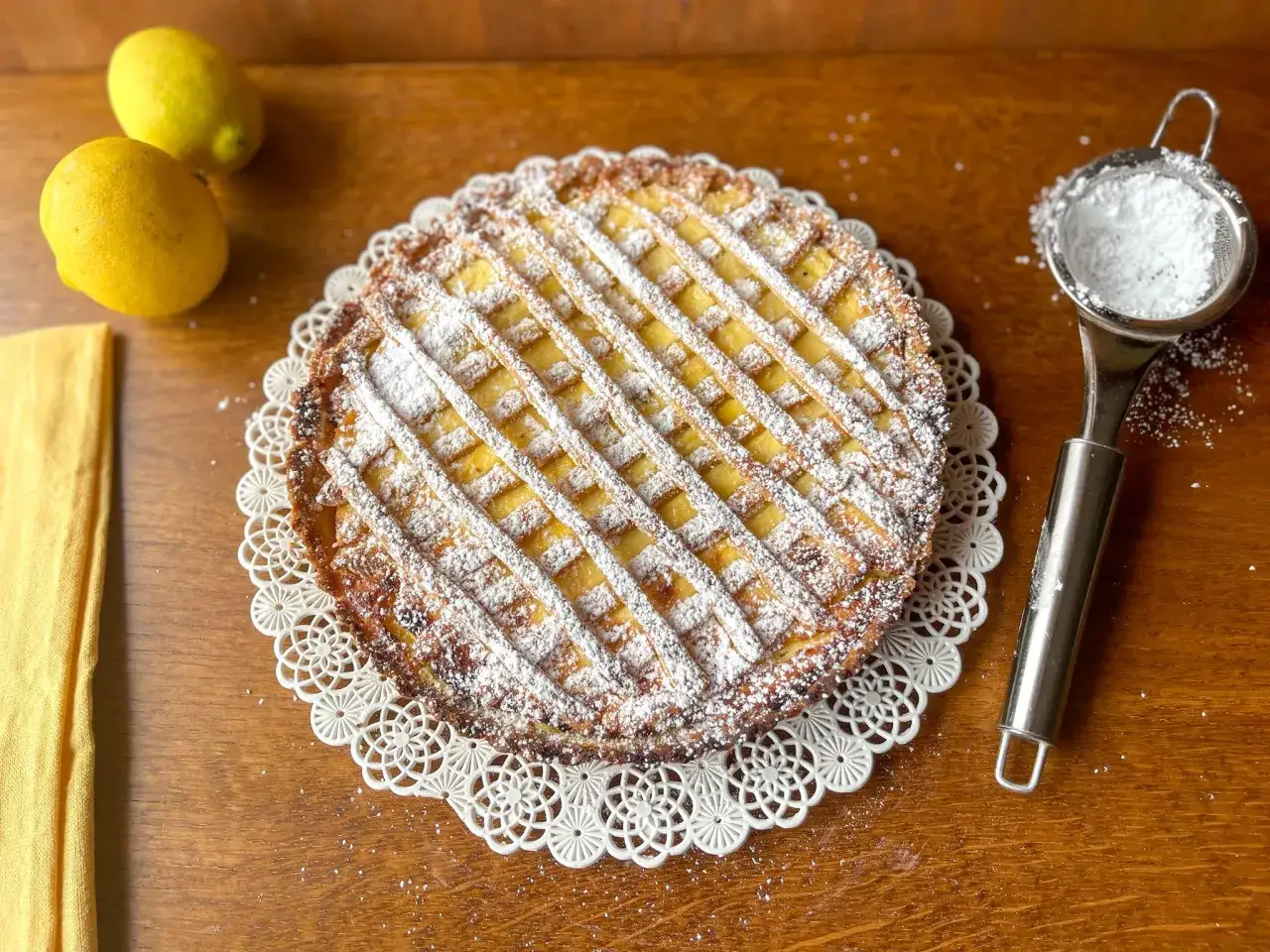 Deliziosa crostata babbaiola con scorze di limone, cosparsa di zucchero a velo, pronta per essere gustata.