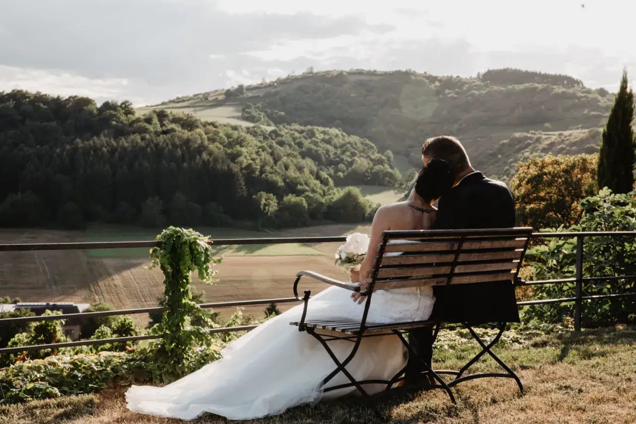 Brautpaar genießt den Ausblick auf einem Weingut. Die romantische weingut hochzeit wird durch die malerische Landschaft und das warme Abendlicht perfekt eingefangen.