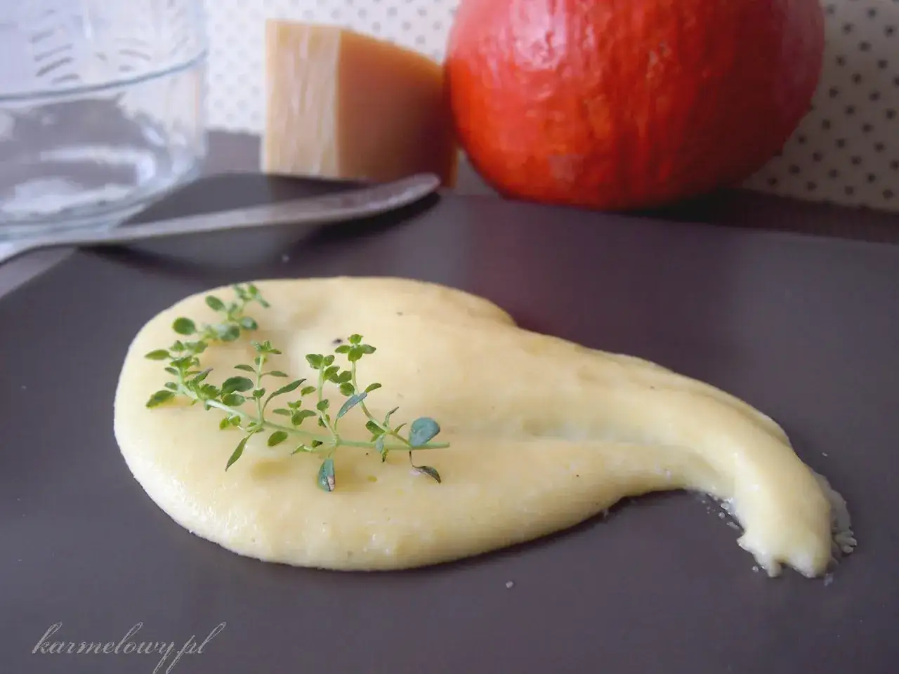 Kremowa polenta co to? Delikatna kaszka kukurydziana z gałązką tymianku, obok dynia i ser.
