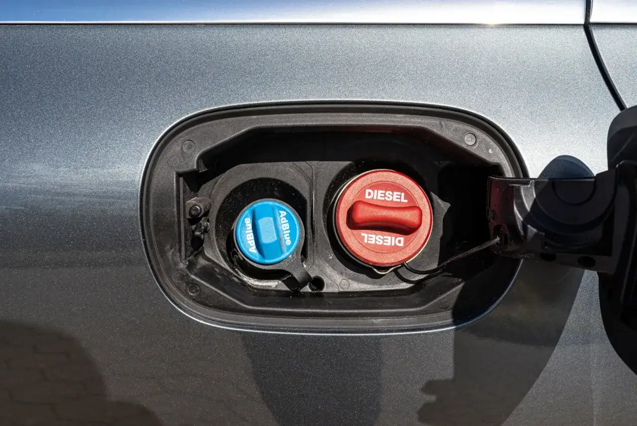 Dwa korki wlewu paliwa: czerwony z napisem DIESEL i niebieski z napisem AdBlue. Pamiętaj, jak jeździć dieslem i gdzie tankować.