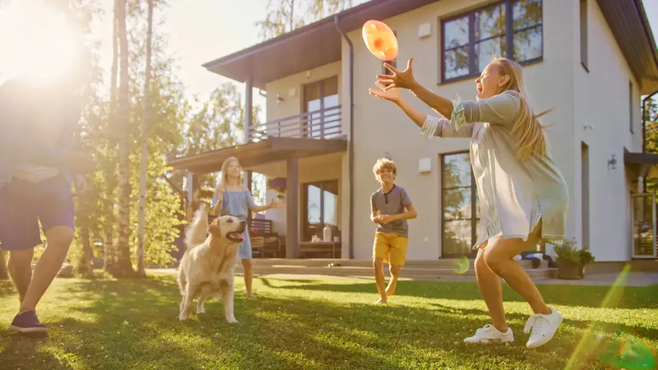 Radosny golden retriever w pełni pokazuje swój przyjacielski charakter, bawiąc się z rodziną w ogrodzie.