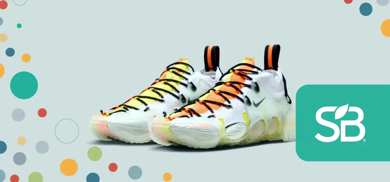 Kolorowe buty Nike z serii Move to Zero, z pomarańczowymi i żółtymi akcentami, na jasnoszarym tle z kropkami.