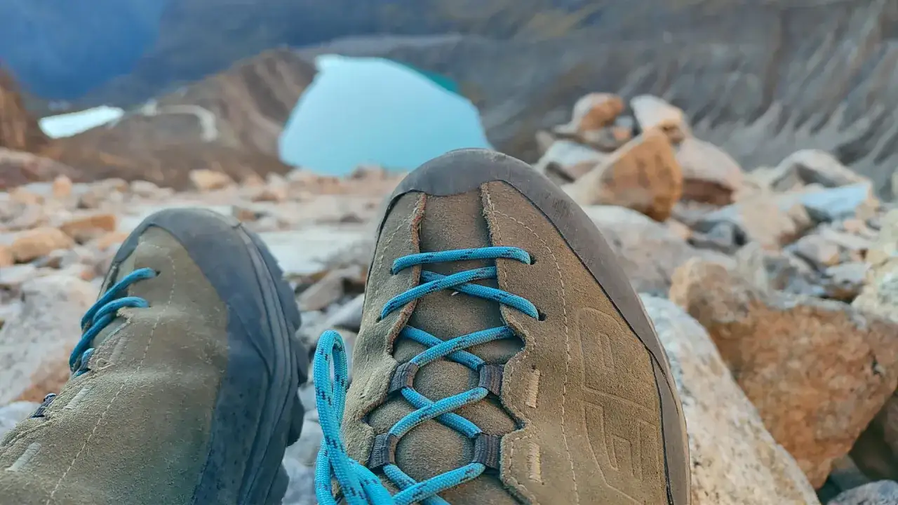 La Sportiva TX4 Evo na kamienistym szlaku, z widokiem na turkusowe jezioro w g&oacute;rach.