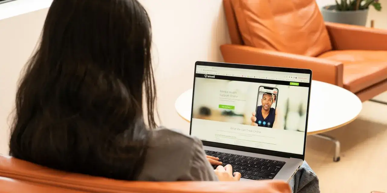 Kobieta korzysta z laptopa, szukając wsparcia psychologicznego online. Psycholog praca zdalna to wygoda i dostępność.