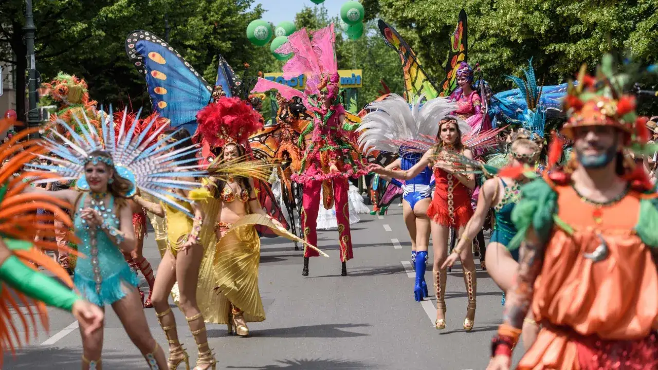 Bunte Kost&uuml;me und Schmetterlingsfl&uuml;gel beim Karneval in Berlin. Menschen in fantasievollen Outfits ziehen durch die Stra&szlig;en.