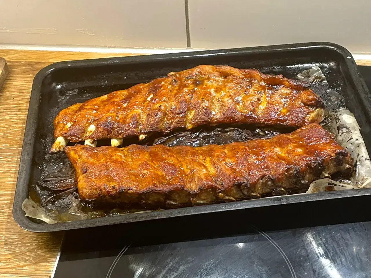 Två ugnsbakade kamben, glaserade och gyllene, ligger på en plåt.