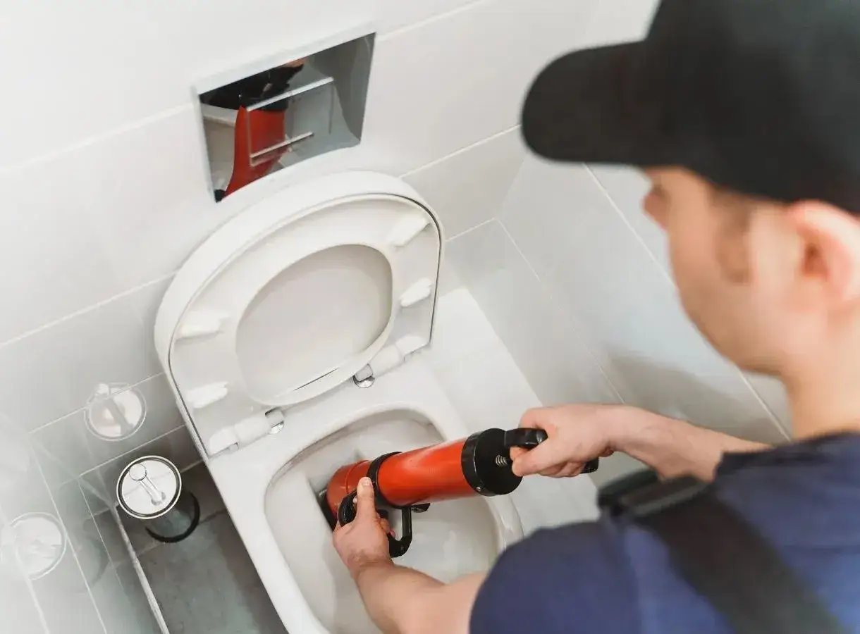 Idraulico usa uno sturalavandini per risolvere il problema di una cassetta a muro wc che perde acqua.
