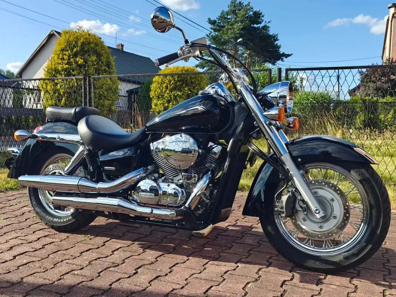 Czarny motocykl Honda Shadow 750, błyszczące chromy, idealny do podróży. Dane techniczne dostępne dla zainteresowanych.