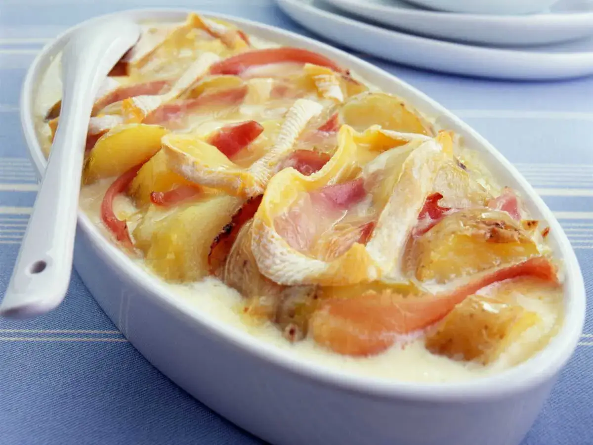 Plat gratiné de pommes de terre, fromage fondant et fines tranches de jambon cru. Un délice de tartiflette jambon cru.