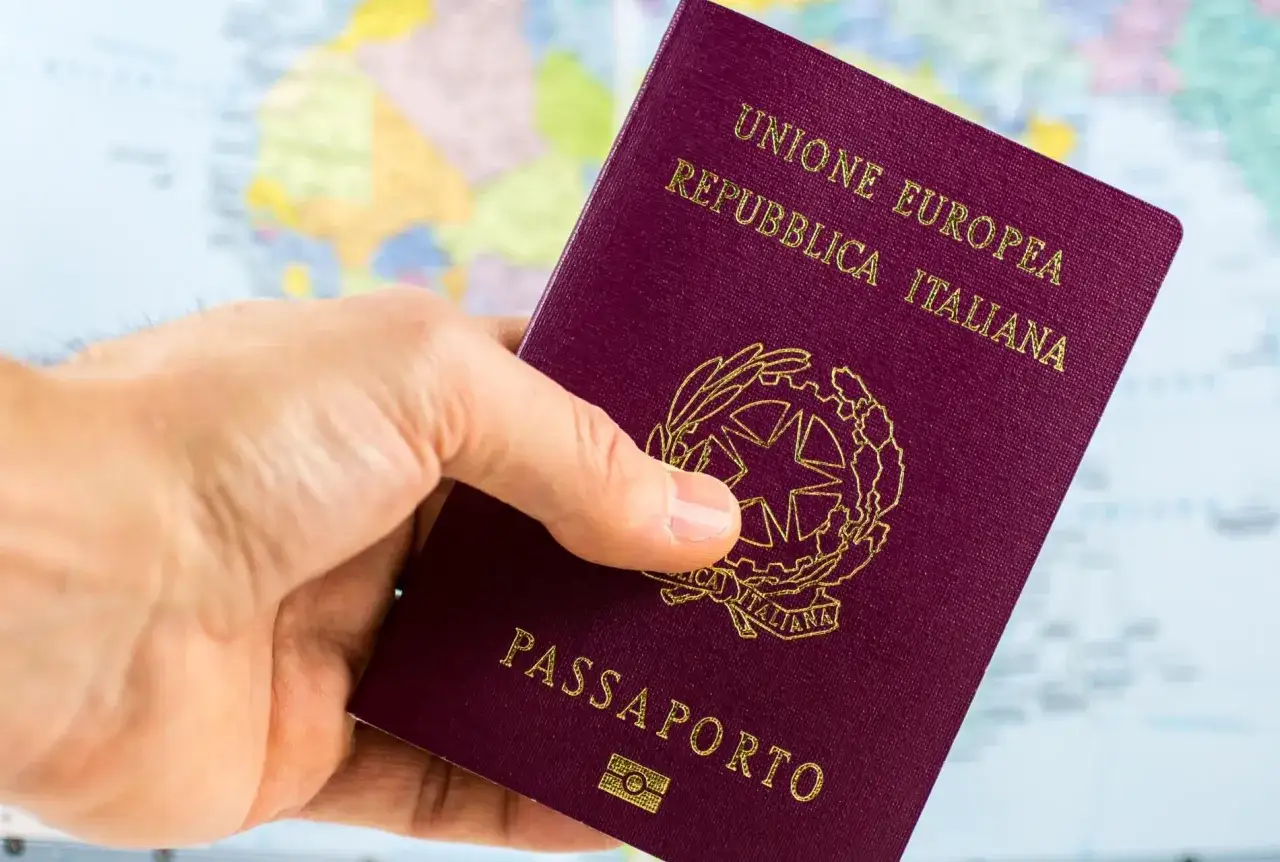 Passaporto italiano in mano, pronto per i documenti di viaggio MSC Crociere. Sfondo mappa del mondo.