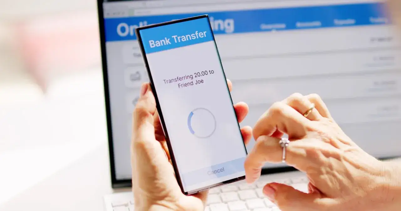 Mani che effettuano un bonifico istantaneo da smartphone. Il limite di quanti bonifici istantanei si possono fare in un giorno dipende dalla banca.