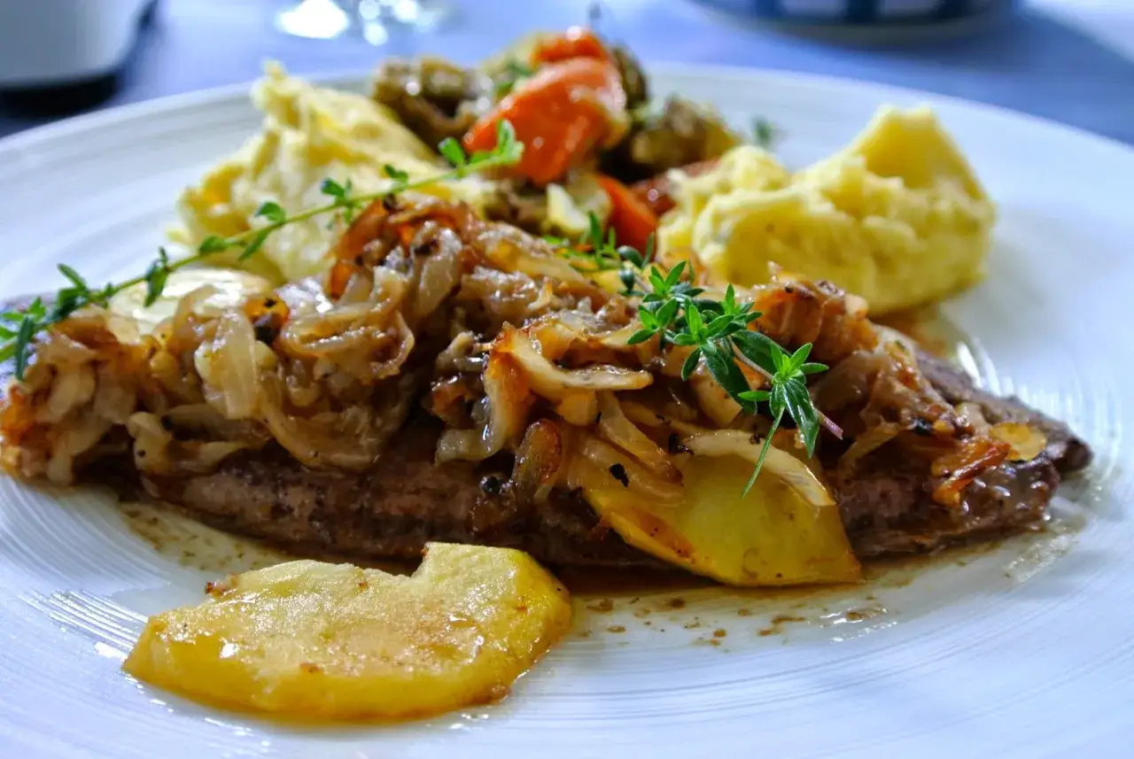 Leber Berliner Art mit Kartoffelp&uuml;ree und karamellisierten Zwiebeln, garniert mit frischen Kr&auml;utern.