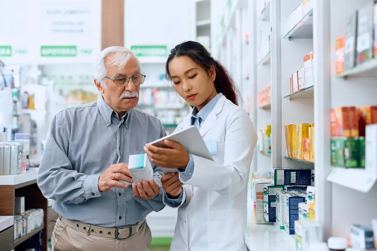 farmaceuta w aptece rozmawiający z seniorem