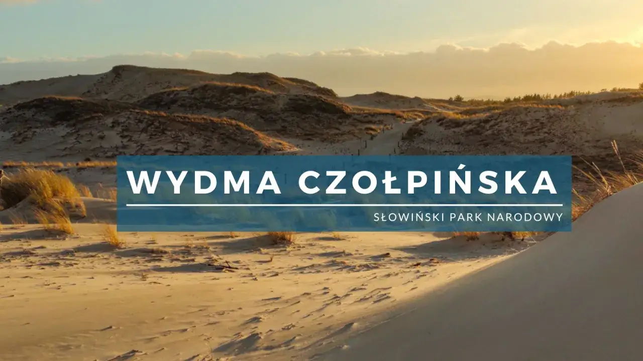 Złociste piaski wydmy czołpińskiej oświetlone zachodzącym słońcem. W tle widać łagodne wzg&oacute;rza i niebo z chmurami.