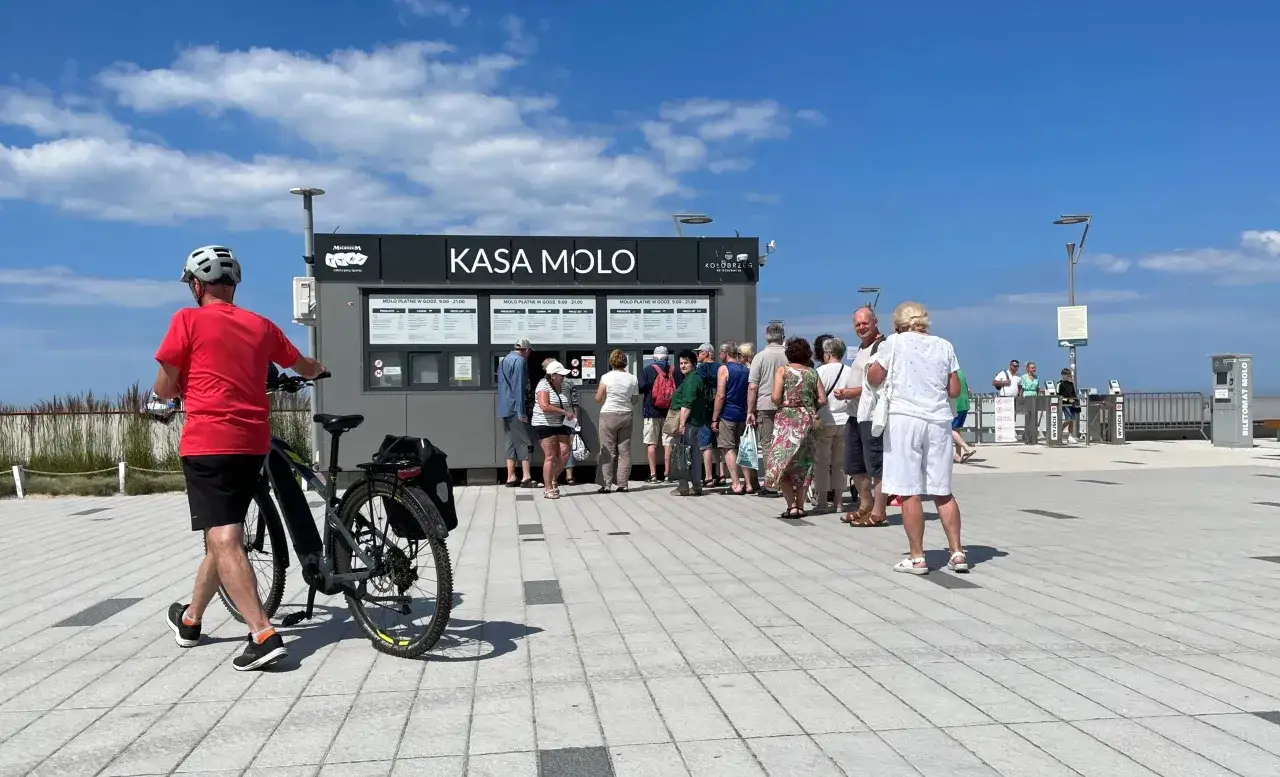 Kasa Molo w Kołobrzegu. Kolejka ludzi czeka na bilety. Czy molo w Kołobrzegu jest płatne? Tak, w godzinach 9:00-21:00.