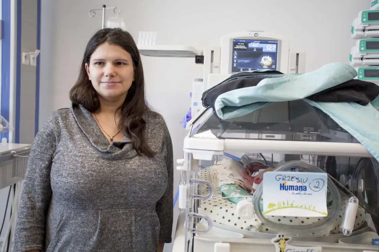 Szpital Żwirki i Wigury, porodówka. Mama z noworodkiem w inkubatorze, otoczeni sprzętem medycznym.