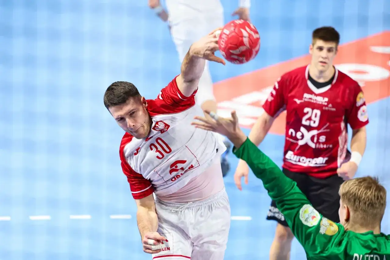 Piłkarz ręczny Polski z numerem 30 rzuca piłkę, próbując pokonać bramkarza. Mecz Polska Łotwa.