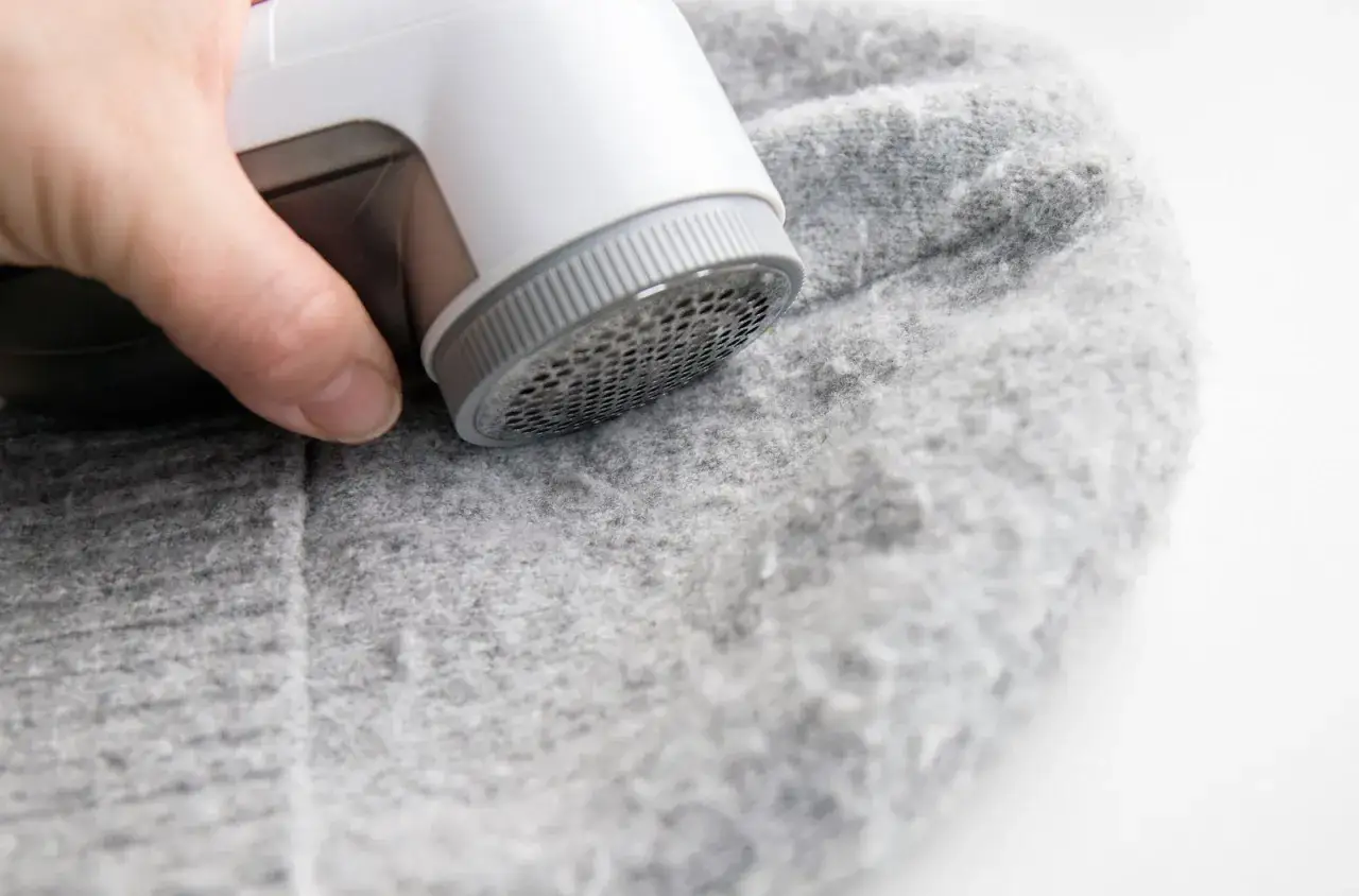Ein Wollpullover, der eingelaufen ist, wird mit einem Fusselrasierer wieder sch&ouml;n gemacht.