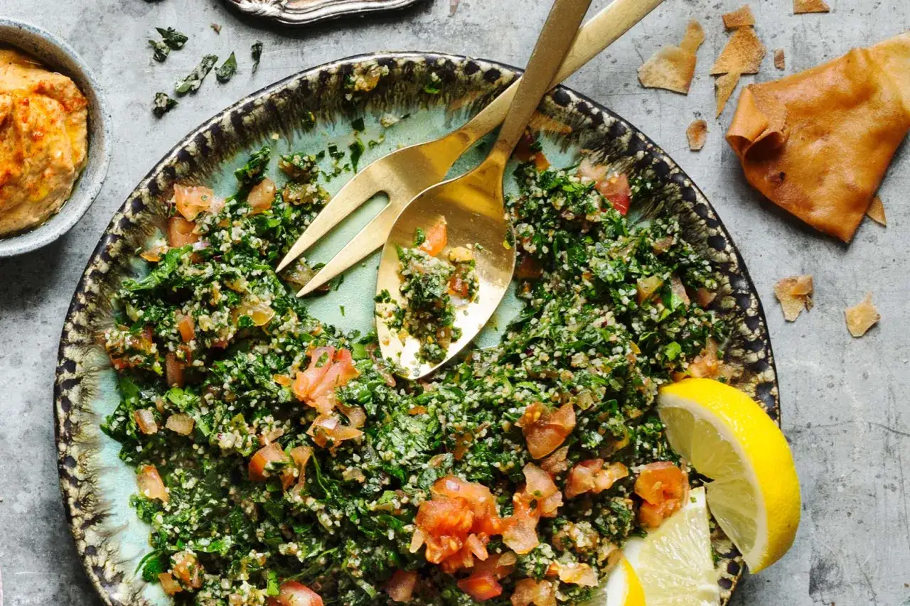 En fräsch tabbouleh med persilja, tomat och bulgur, serverad med citronklyftor och pitabröd. Ett perfekt tabbouleh recept för sommaren.