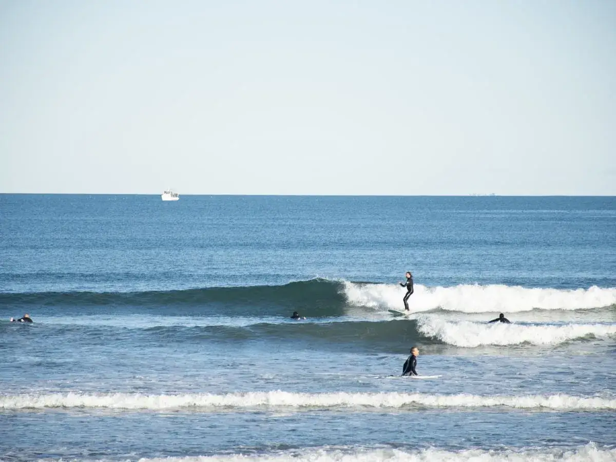 Surfer auf Wellen vor Spanien. Eine Karte mit Surfspots Spanien wäre hier nützlich, um die besten Wellen zu finden.