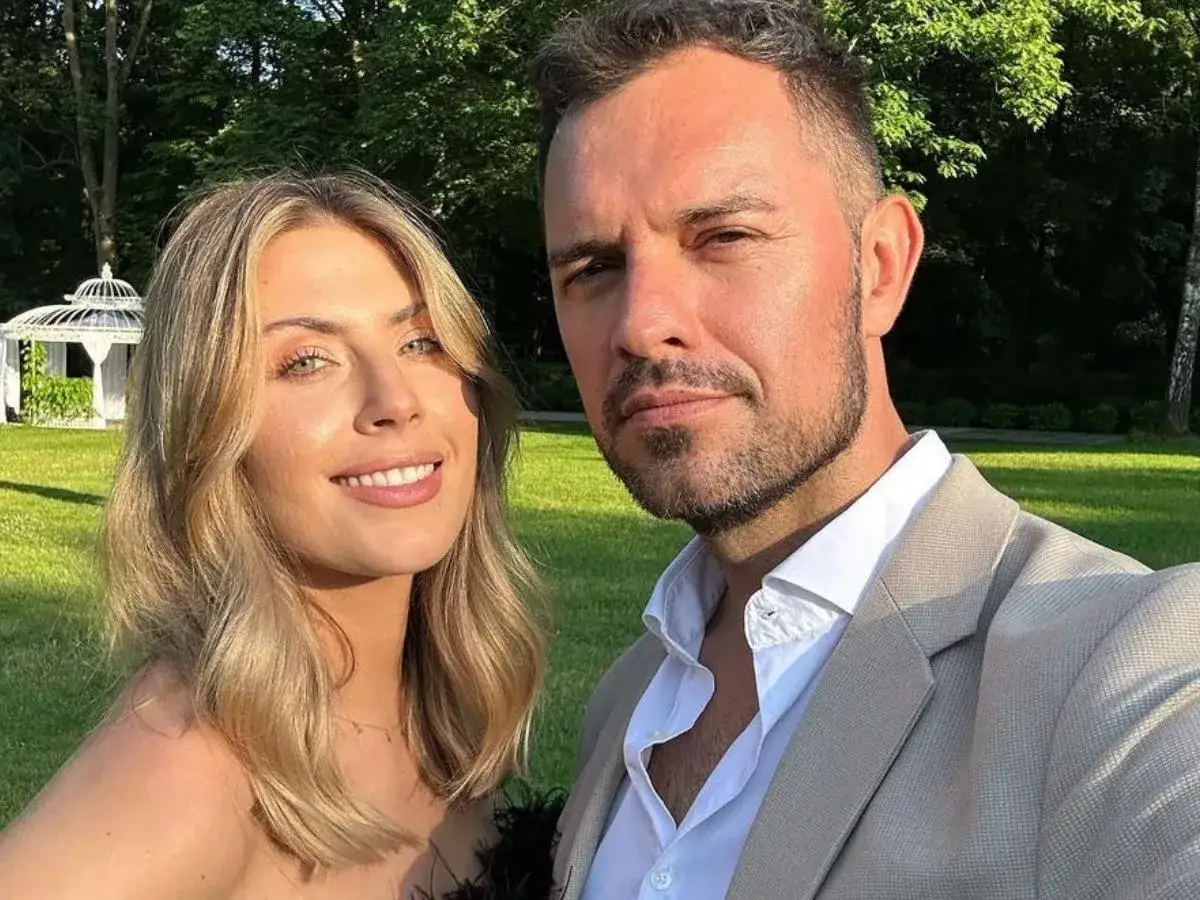 Aleksandra Grysz z mężem na tle ogrodu z altanką.