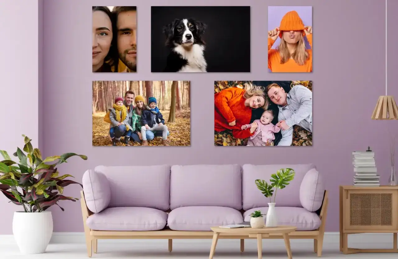 Un mur violet orn&eacute; de cinq toiles : un couple, un chien, une jeune femme, une famille en for&ecirc;t et une famille sur des feuilles d'automne. Une belle id&eacute;e tableau cr&eacute;atif pour d&eacute;corer un salon.