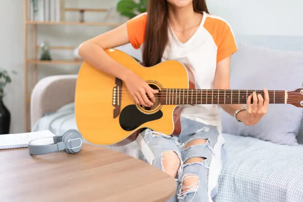 gitara akustyczna dla początkujących, osoba trzymająca gitarę