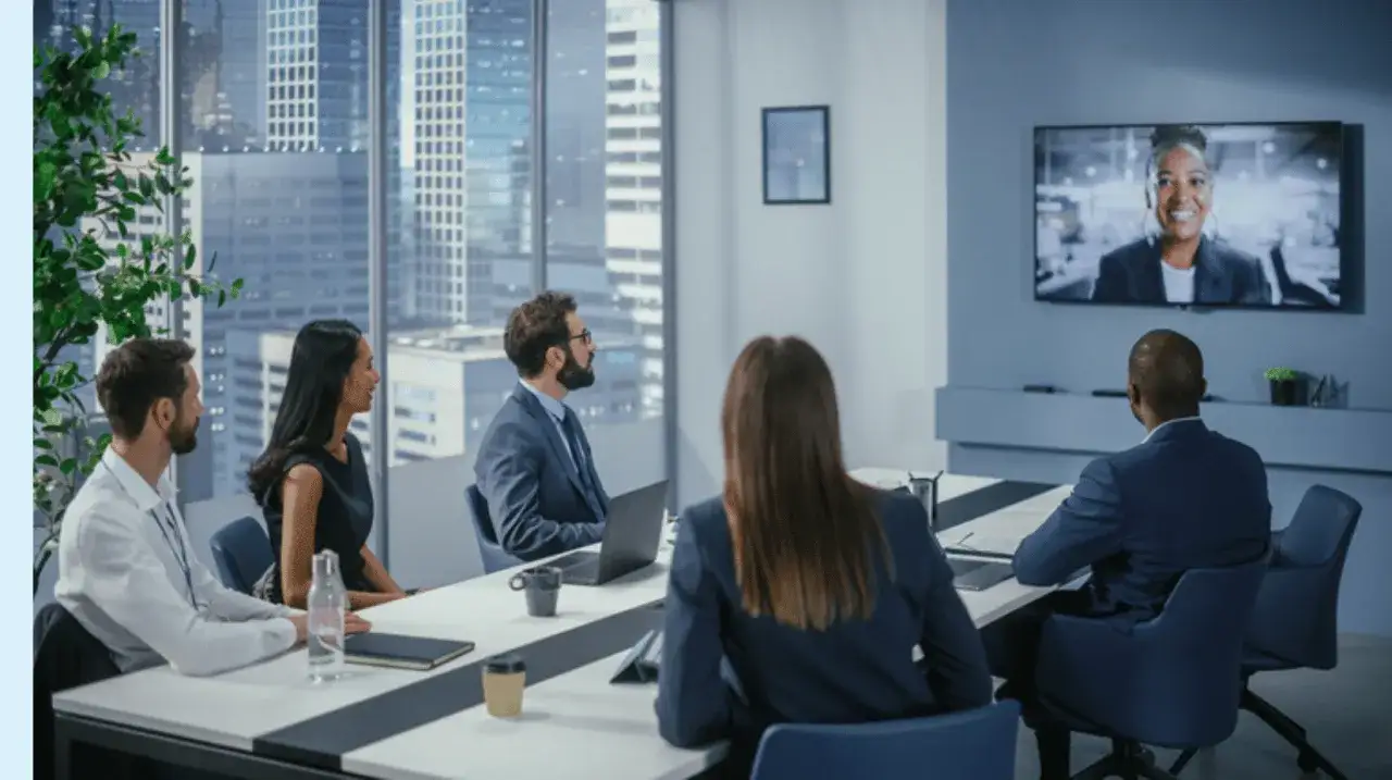 Teammeeting mit Videokonferenz. Die Teilnehmer zeigen soziale Intelligenz, indem sie aufmerksam der Kollegin auf dem Bildschirm folgen.